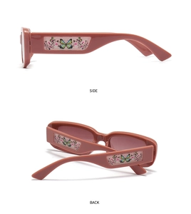 Détail de lunettes de soleil tendance à petite monture avec motifs papillon et fleurs