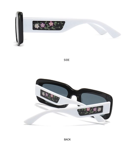 Detail of square sunglasses with black frames and white floral patterned temples side view