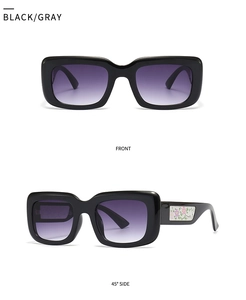 Macro view of black square sunglasses with purple gradient lenses and floral temples