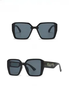 Detailed front and side view of oversized square black sunglasses with floral butterfly motif
