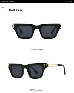 Détail des lunettes de soleil carrées noires avec charnières en métal doré et verres foncés
