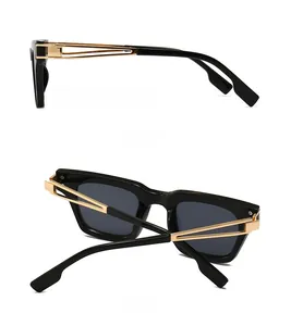 Détail des lunettes de soleil carrées avec branches dorées ajourées et verres foncés