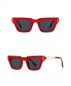 Détail de lunettes de soleil rectangulaires rouges avec verres gris et accents dorés