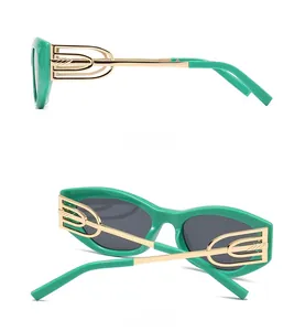 Detail view of green cat eye sunglasses with golden geometric temple accents