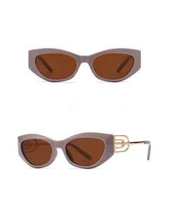 Detail view of cat eye sunglasses with gray tea lenses and golden hollow metal temples