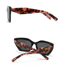 Detail view of tortoiseshell square sunglasses with triangle logo and grey lenses