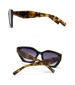 Detail view of tortoiseshell sunglasses featuring black triangle decor and purple lenses