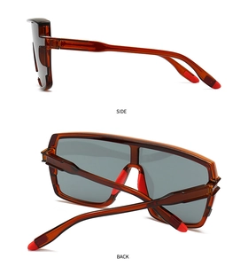 Side and back view of oversized brown translucent sunglasses with red rubber accents