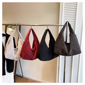 Detail of four retro corduroy tote bags with metal zippers and half-moon silhouette