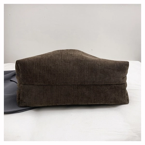 Detail view of the flat rectangular base and ribbed corduroy texture of the tote bag