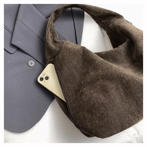 Detail of dark brown corduroy tote bag featuring a convenient side zipper pocket
