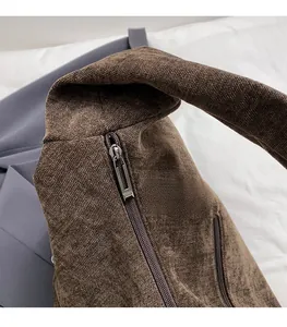 Close-up of durable metal zipper and brown canvas texture on a large tote bag
