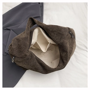 Detail view of large brown canvas tote bag interior with inner pocket and zipper
