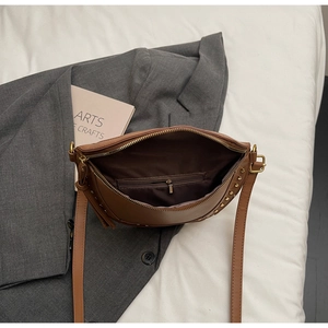 Macro detail of brown leather bag interior with zipper pocket and metal rivets