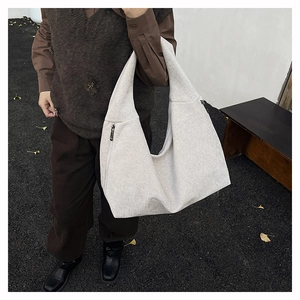 Detail of a large canvas tote bag showing side zipper hardware and heavy fabric texture