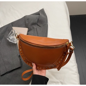 Detailed close-up of brown crescent saddle bag with gold studs and smooth texture finish