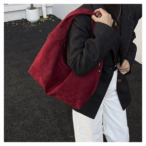 Macro detail of wine red corduroy hobo bag with side zipper and textured fabric