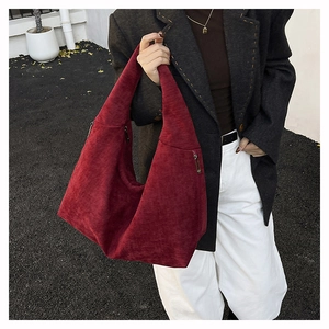 Macro shot of dark burgundy suede hobo bag detailing soft texture and side zipper
