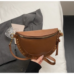 Detail of vintage brown leather crossbody bag with golden rivet accents and metal zipper