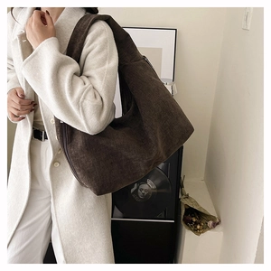 Detail of dark brown corduroy tote bag showing textured fabric and spacious shoulder design