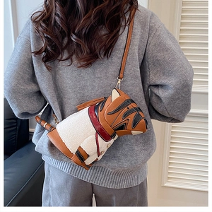 Detail of adorable dachshund-shaped crossbody bag with brown leather and plush texture