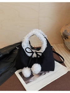 Detail showing plush black crossbody bag with white faux fur handle and bow charms