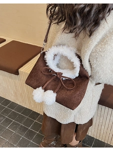 Detail of cute dark brown plush bag with white faux fur trim and bow pom-pom accents