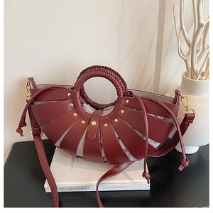 Detail of burgundy woven basket bag with gold rivets and inner drawstring pouch