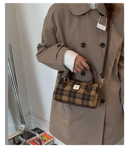 Detail of vintage plaid Boston bag showing brown leather handles and brand logo tag