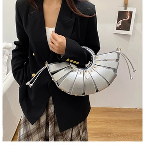 Close-up of silver woven handbag with metallic pleated leather and ring top handle