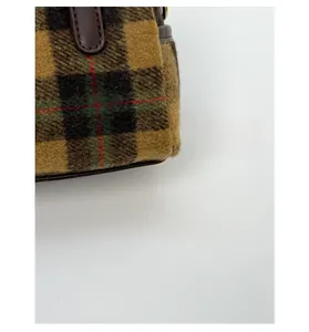 Detailed macro view of retro plaid wool fabric and durable brown leather trim