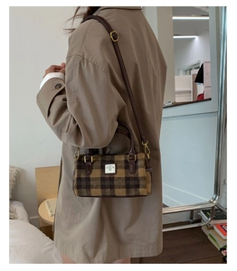 Brown plaid wool Boston bag shown on model with beige trench coat and adjustable strap