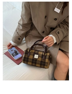 Detailed view of the plaid wool Boston bag with brown top handles and golden hardware