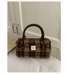 Detail of vintage brown plaid boston bag with wool texture and golden metal hardware