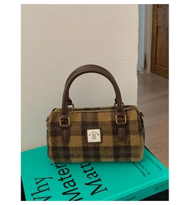 Detail of wool plaid Boston bag with leather handle and golden metal connector
