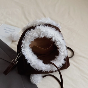 Close-up of vintage brown suede shoulder bag with white faux fur trim and interior pocket