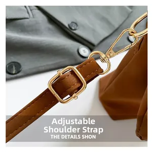 Detail of brown leather adjustable shoulder strap with premium gold metal buckle