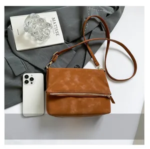 Detail of vintage brown frosted leather bag with gold hardware and removable shoulder strap