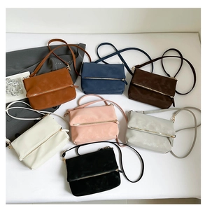 Detailed overhead view of multiple vintage matte leather saddle bags in seven elegant colors