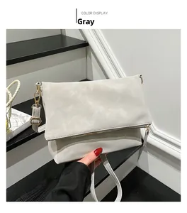 Detail view of the gray crossbody bag with matte texture and light gold metal hooks