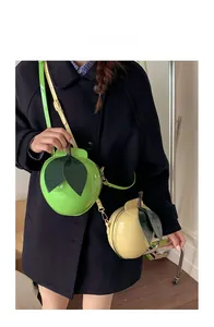Detail of creative 3D fruit-shaped crossbody bags in green and yellow glossy finish