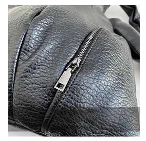 Detail of smooth silver zipper hardware on black litchi textured leather backpack