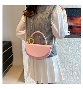 Detailed back view of model wearing pink saddle bag with golden metal ring handle