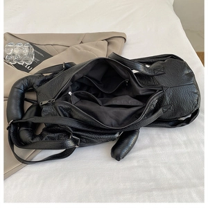 Detail view of large black backpack showing spacious interior with zipper and open pockets
