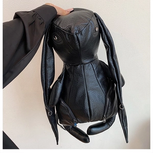 Detail of black rabbit-shaped backpack in pebbled PU leather with metallic eyelet accents