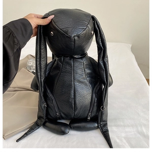 Macro detail of quirky black rabbit backpack featuring long ears and silver dual zippers