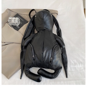 Detail of bunny-shaped black backpack with lychee grain texture and silver metal eyelets
