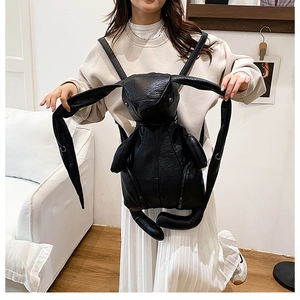 Close-up of a large black rabbit-shaped backpack with leather texture on a model