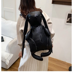 Macro view of black rabbit-shaped backpack featuring textured lychee pattern PU leather