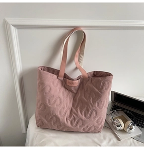 Detail of S-quilted texture and brand logo on a large capacity pink tote bag